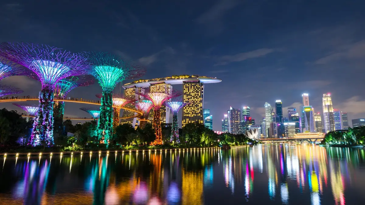 Singapore Marina Bay skyline and Gardens by the Bay Supertrees glowing at night with reflections on the water