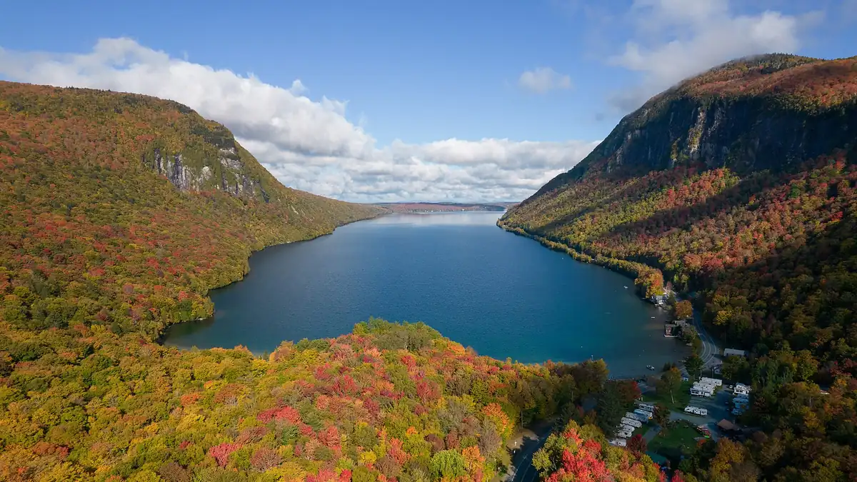 Peak fall foliage in red, orange and gold around Lake Willoughby in Vermont, one of the best places to visit in US for fall
