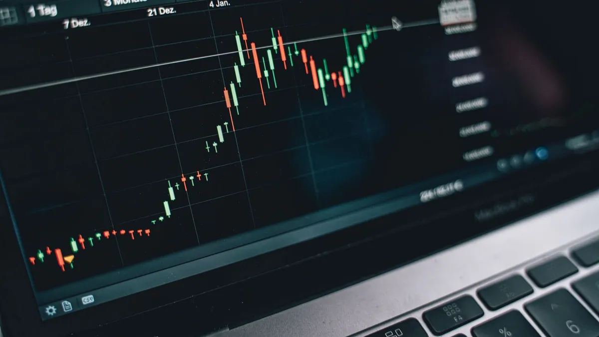 Candlestick price chart on a laptop screen, illustrating how crypto asset prices move over time