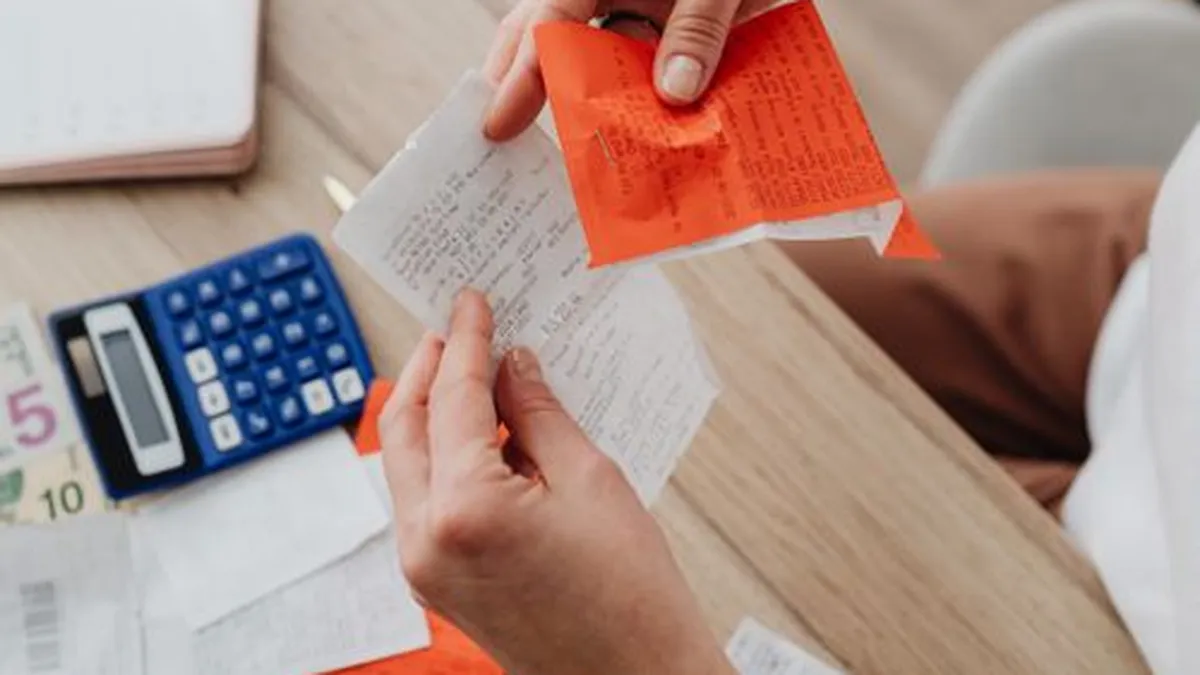 Top view of a desk with a calculator, receipts and handwritten notes for organising crypto tax records