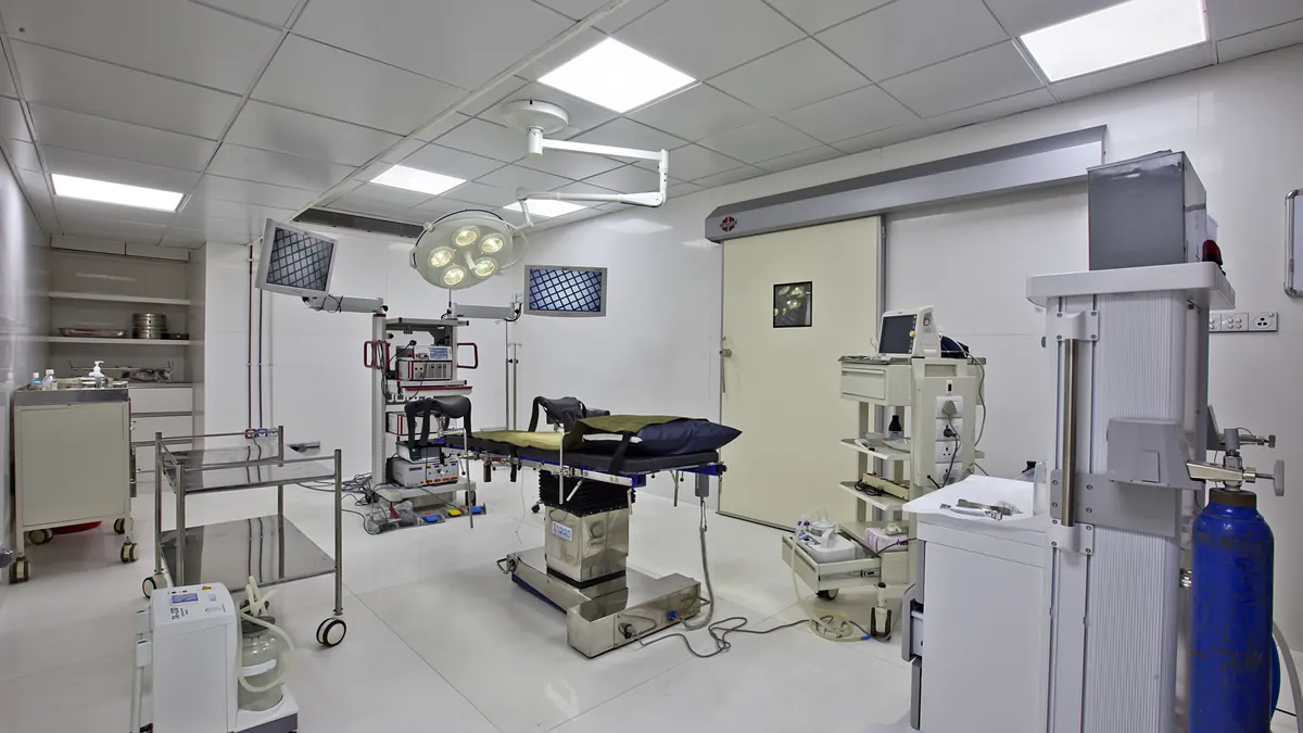 Modern laparoscopic operating theatre with a surgical team in sterile dress working around advanced operating equipment
