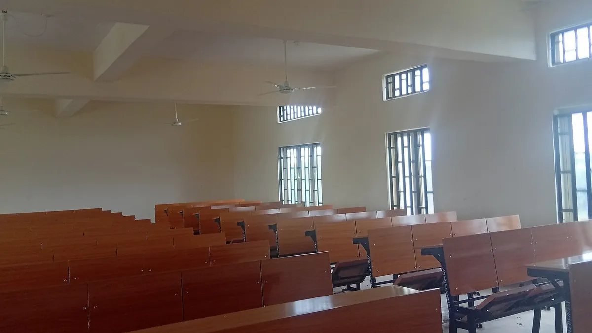 Empty classroom with rows of desks, seen from the side in natural light