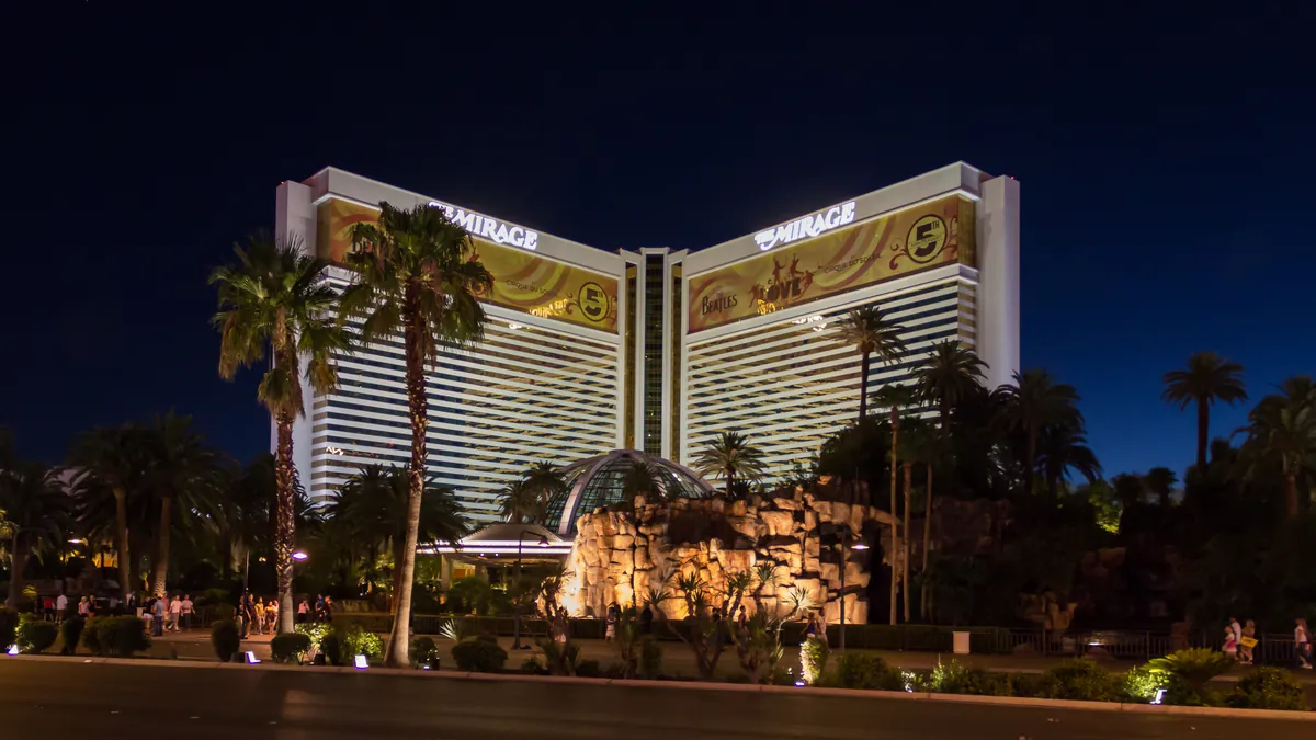 The Mirage casino hotel on the Las Vegas Strip illuminated at night, with palm trees in front