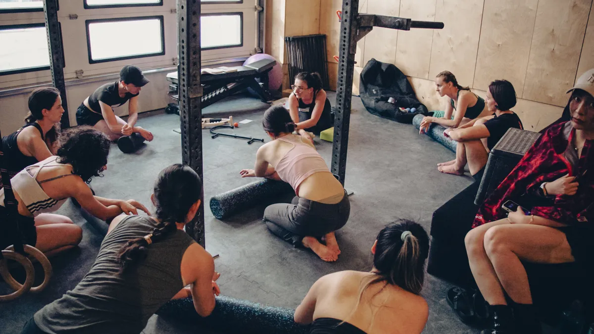 Employees stretching during a group fitness session in a gym, an example of the wellbeing activities the OSU lifestyle spending account can reimburse
