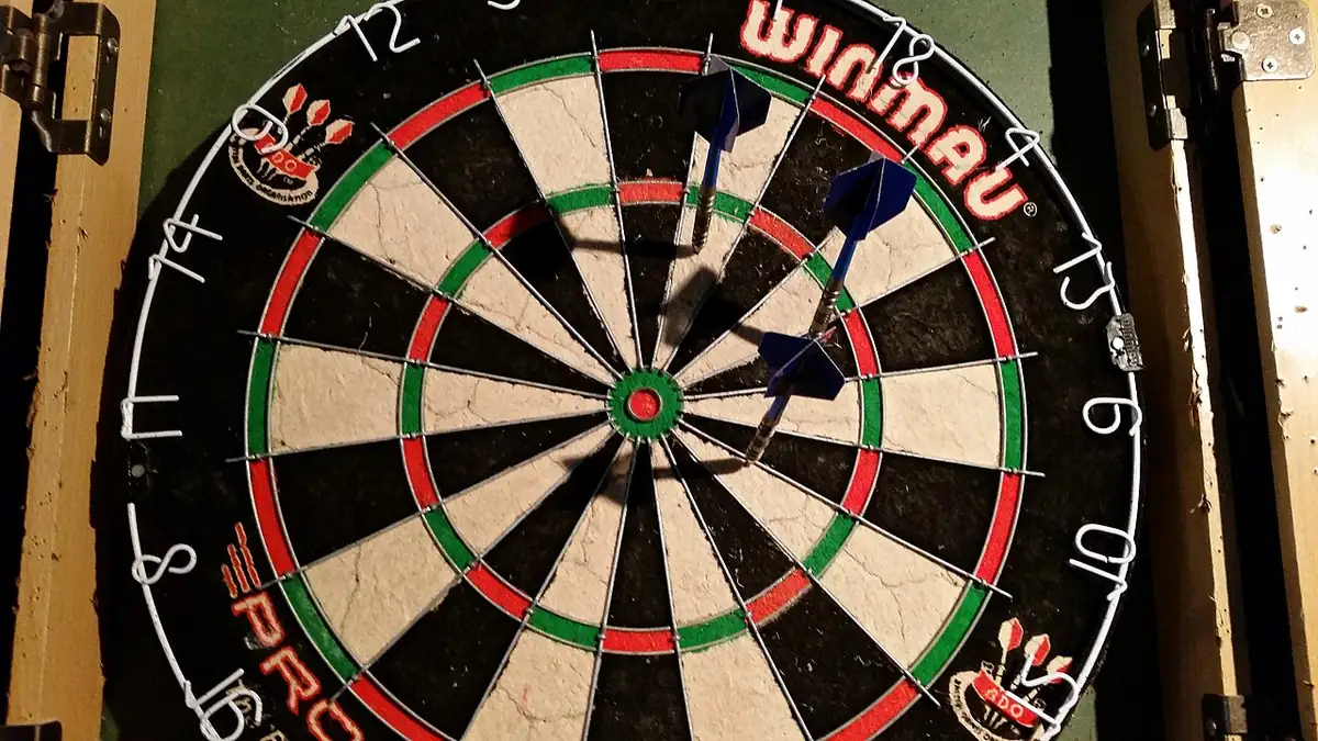 Close-up of a dartboard with darts in play, representing the precision behind Michael Smith's nine-dart finish