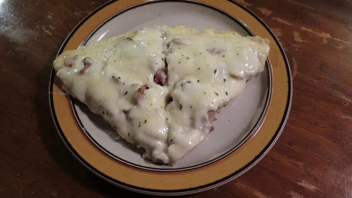 Two pizza slices with melted cheese and vegetable toppings ready to share