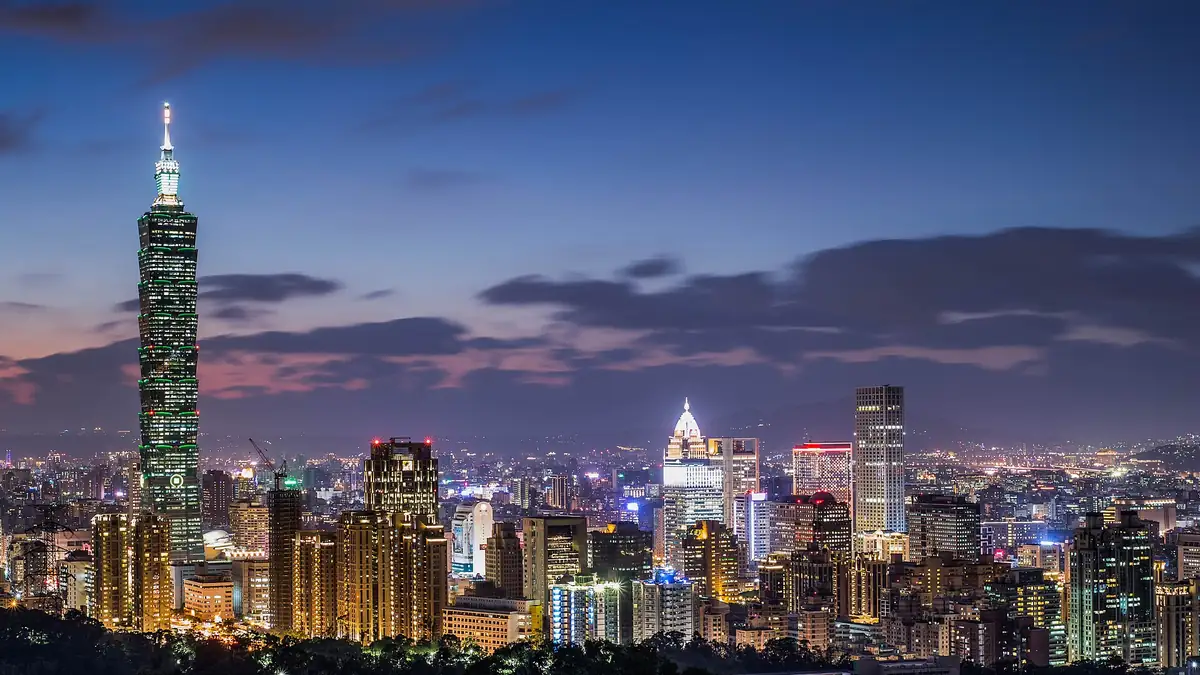 Taipei skyline at night with the illuminated Taipei 101 tower rising above the city lights