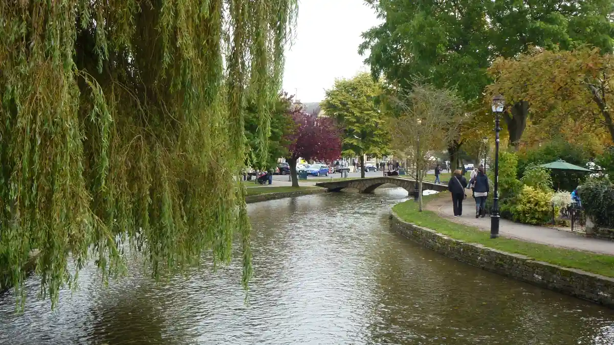 The River Windrush and a low stone bridge in Bourton-on-the-Water, a classic Cotswolds village on a day trip from Stratford-upon-Avon