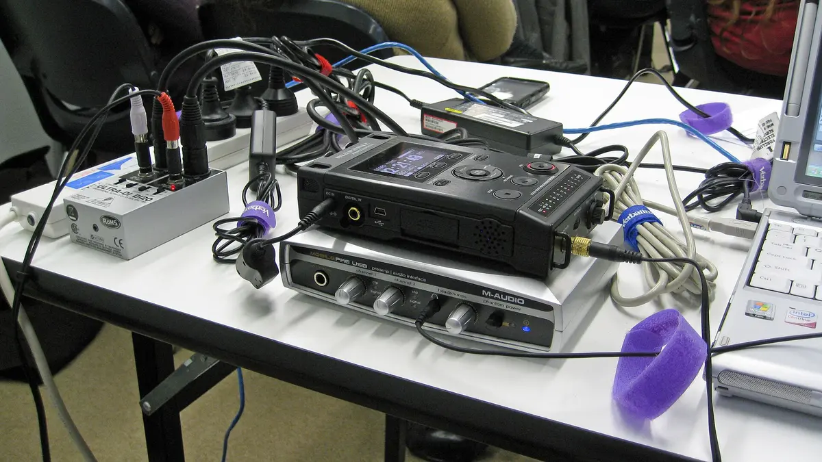 Podcast and webinar recording equipment on a desk with an audio interface, recorder and laptop for a creator platform setup
