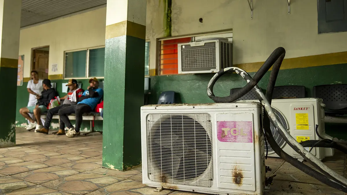 HVAC technicians servicing an air conditioning system during a repair visit