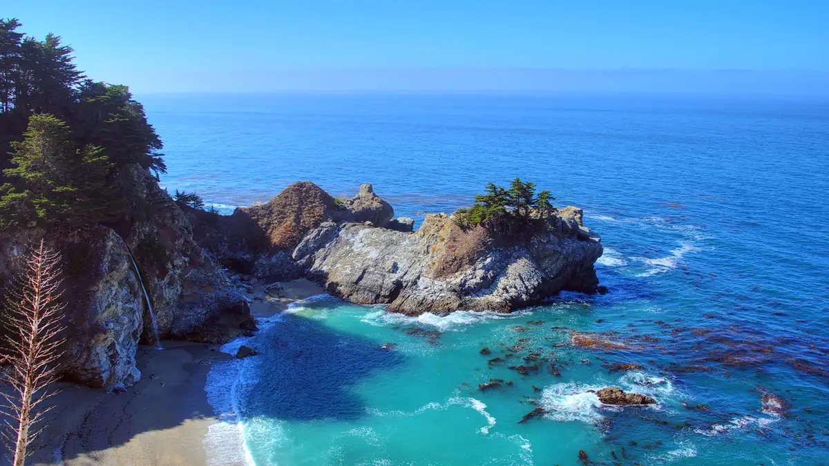McWay Falls dropping onto a turquoise cove beach in Big Sur on the California coast