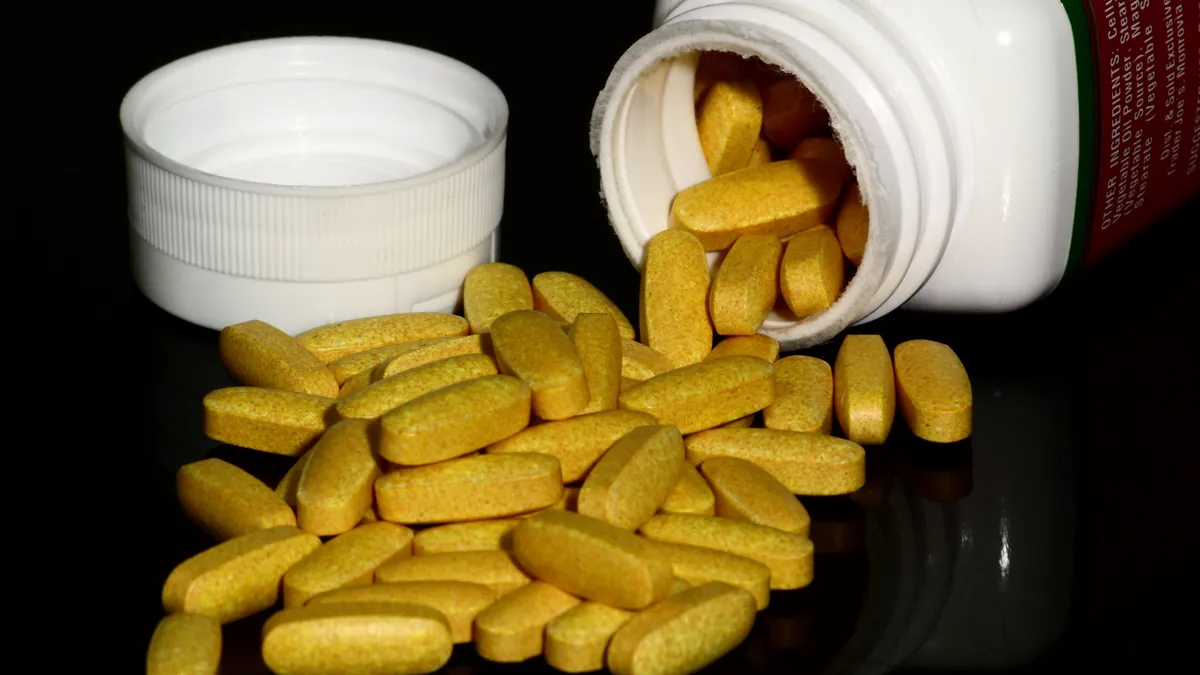 B vitamin supplement tablets beside their bottle, illustrating how to read a supplement label carefully