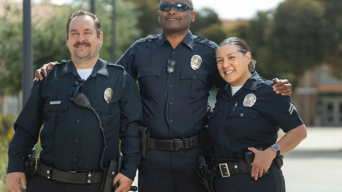 Group of police officers in uniform standing together outdoors and smiling